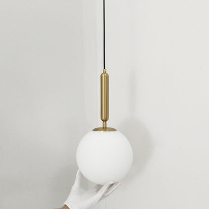Подвесной светильник в форме золотого стеклянного шара.